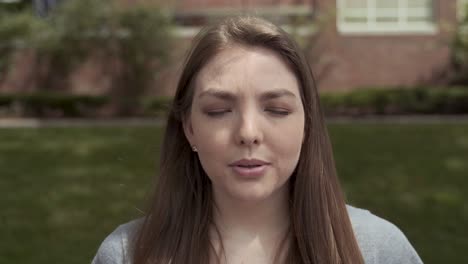 portrait of pretty caucasian girl taking off face mask outdoors, looking at camera, close up shot, dolly movement