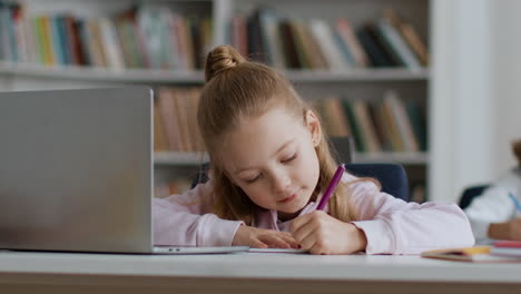 girl student doing homework in library