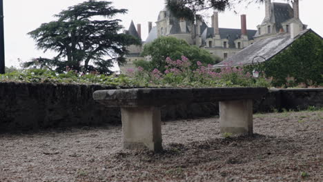 stone park bench under pine tree overlooking old castle in france