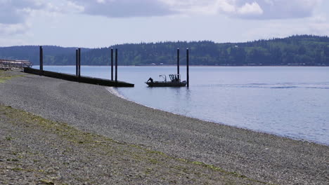 small, nondescript fishing boat cruising past beach at camano island state park, wa state