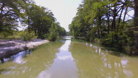 toma aérea de un río a primera hora de la tarde que refleja la tranquilidad de las nubes en su superficie.