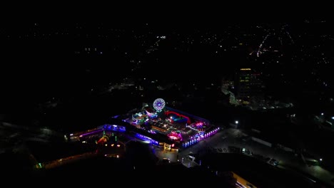 orbiting aerial view of colorful festival pop-up carnival and amusement park caravan during night at virac, catanduanes, philippines