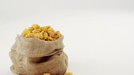 pasta de gnocchi cruda en un saco de hesse sobre un fondo blanco