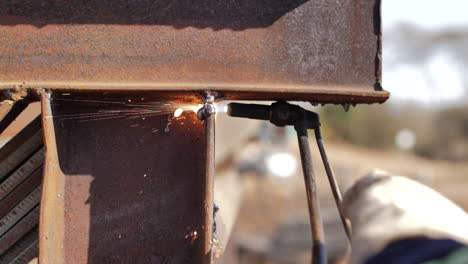 slow-motion of blowtorch cutting through rustic metal