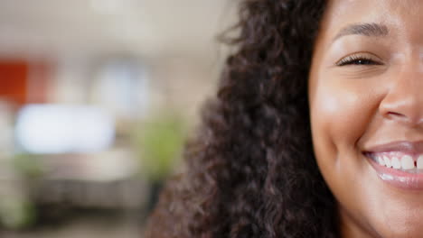 Portrait-of-smiling-casual-biracial-businesswoman-in-office,-slow-motion-with-copy-space