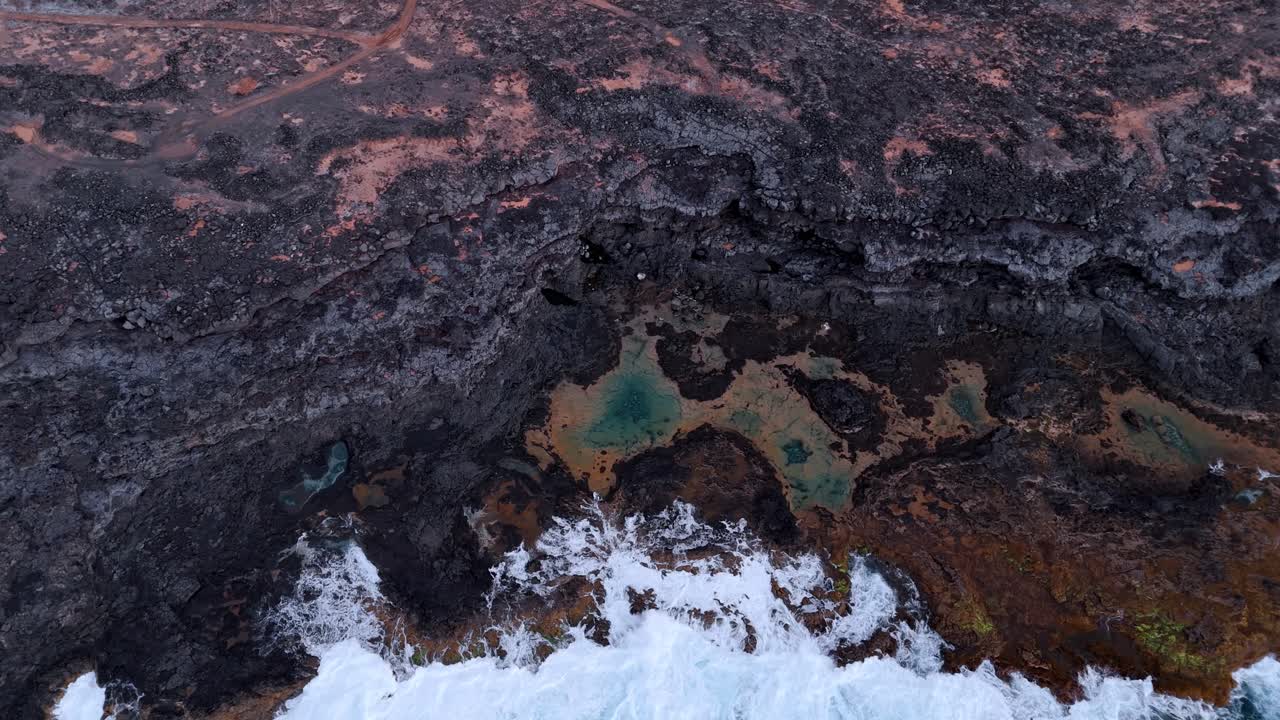 Breathtaking aerial drone footage capturing the stunning Charcones natural pools along the rugged coastline of Lanzarote, Canary Islands.