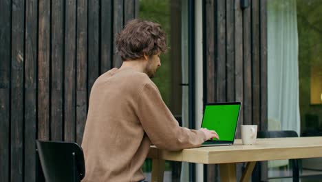 hombre trabajando en una laptop al aire libre