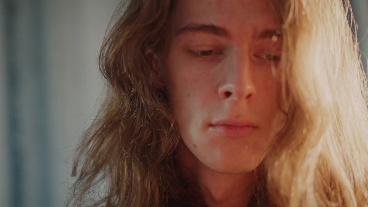Caucasian musician composing reflective melodies. Silent studio scene of thoughtful guitar player. Focused guitarist in quiet room capturing emotional melodies with detailed fingerwork