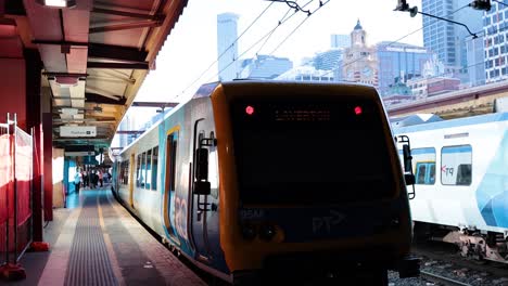 el tren llega a la plataforma de la estación de melbourne.