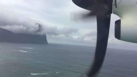 Propeller-aircraft-flying-over-a-lagoon-just-before-landing-at-a-pacific-island