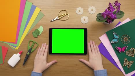 aerial overhead of woman with digital tablet and craft equipment