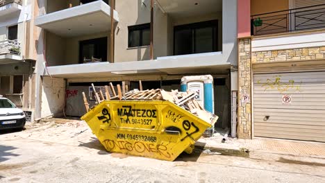 building under construction with a yellow dumpster