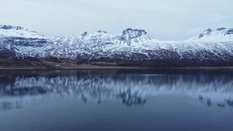 snowy rocky mountains at lakeside on winter day