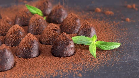 en polvo con trufas de chocolate de cacao en un primer plano de pizarra