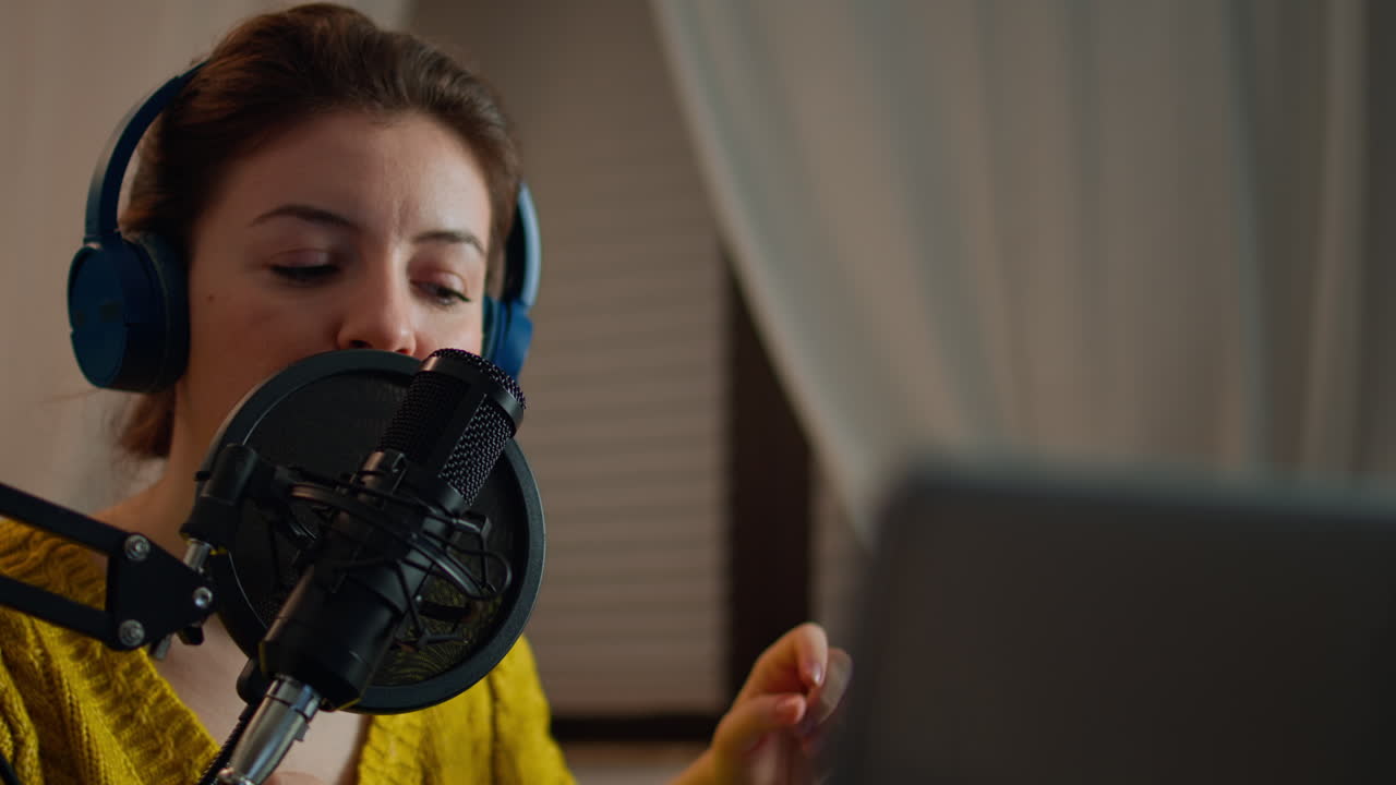 Donna che controlla l’audio prima di registrare un podcast in uno studio casalingo