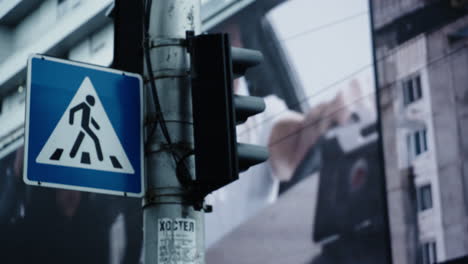 Road-sign-pedestrian-crossing-street-in-city-background-urban-area.