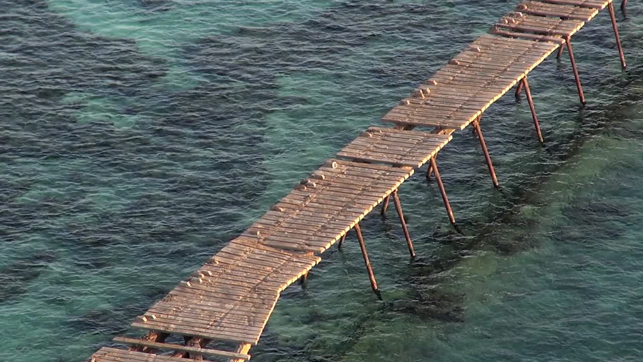 viejo y oxidado muelle devastado en el muelle del faro del arrecife daedalus del mar rojo, egipto