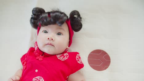 retrato de una linda niña recién nacida asiática en traje rojo tradicional chino, concepto de vacaciones año nuevo chino
