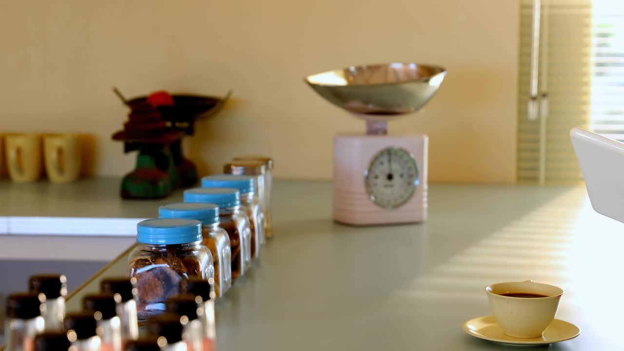 Woman tapping tablet when sipping yellow cup at counter, social media alerts reacting over jars