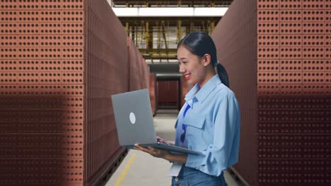 businesswoman working on laptop in a brick factory