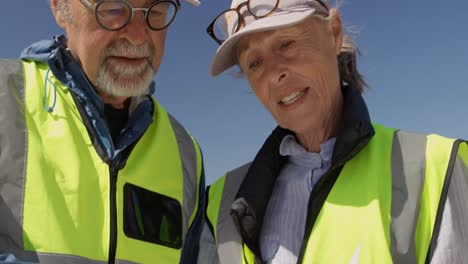 Senior-volunteers-interacting-with-each-other-on-the-beach-4k