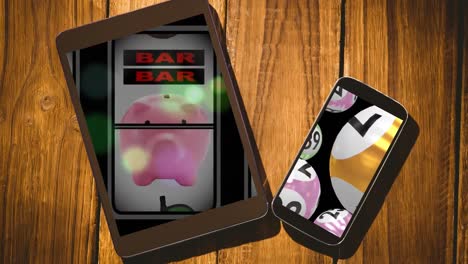 animation of fruit machine and lottery balls on tablet and smartphone on wooden background