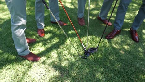 Guys-standing-together-with-golf-clubs-in-the-middle