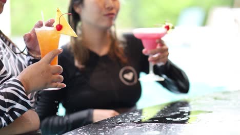 friends sharing drinks at a poolside bar