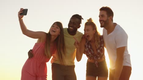 amigos adultos jóvenes tomando moscas en la playa al atardecer 4k