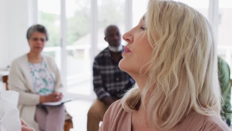 two diverse senior couples sitting in circle having a therapy conversation at home