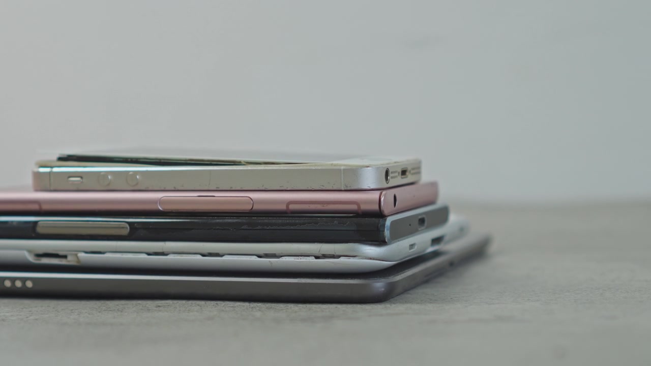 Stos starych, zepsutych smartfonów i tabletów umieszczonych na powierzchni do recyklingu.
