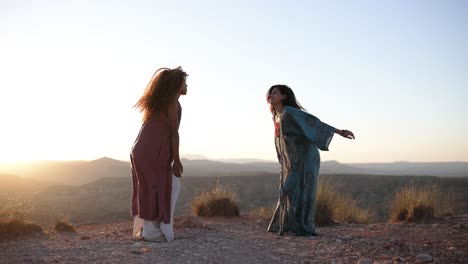two women enjoying sunset in a desert landscape