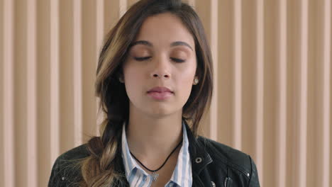 cute-hispanic-woman-close-up-portrait-of-beautiful-young-woman-looking-pensive-contemplative-at-camera-in-wooden-background-wearing-leather-jacket