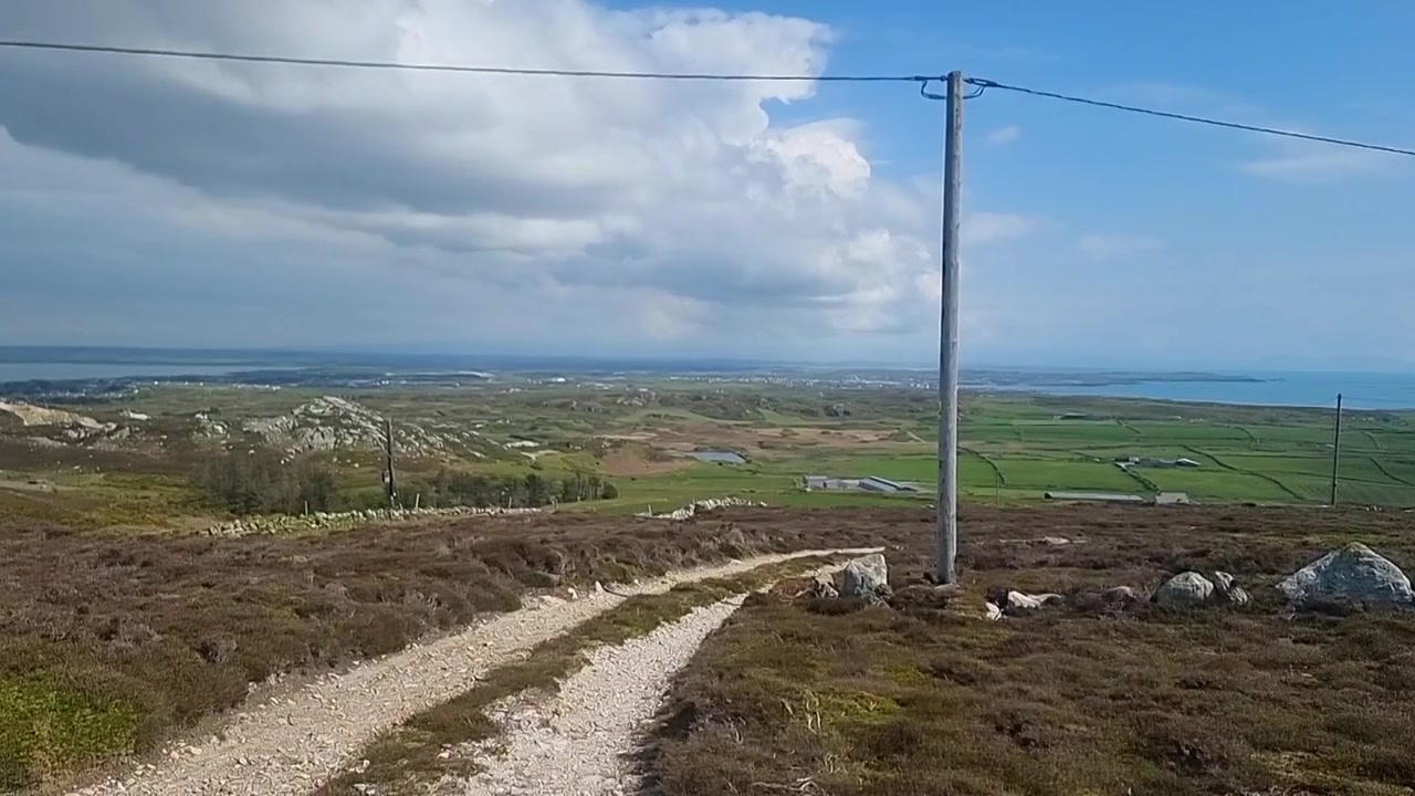 Panoramatická vyhlídka z turistické stezky na hoře Holyhead: telekomunikační věž a velšská venkovská krajina