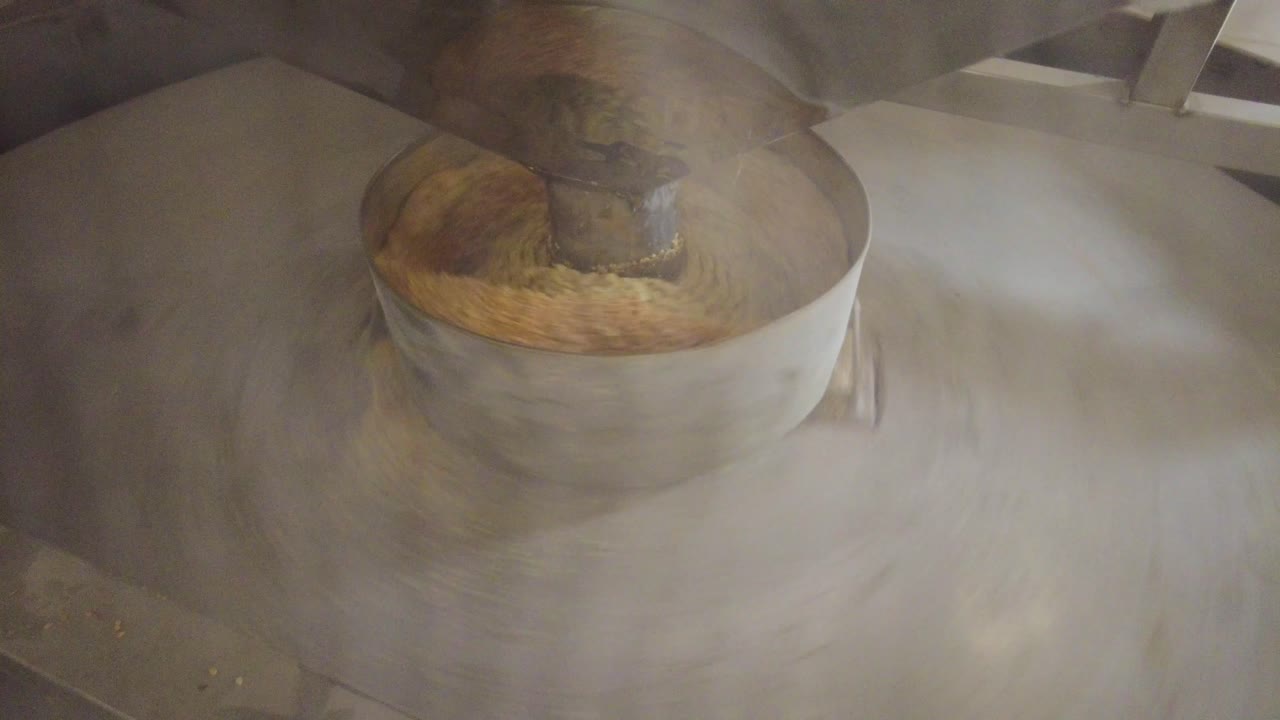 crema de sésamo en la máquina de molino material de acero girar para hacer aceite tahini melaza hacer dulce halvah desierto en irán postre persa cocina cocina gourmet fábrica culinaria de la gente local vida