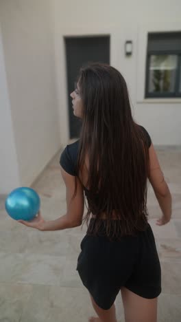 woman practicing aerial arts with a blue ball