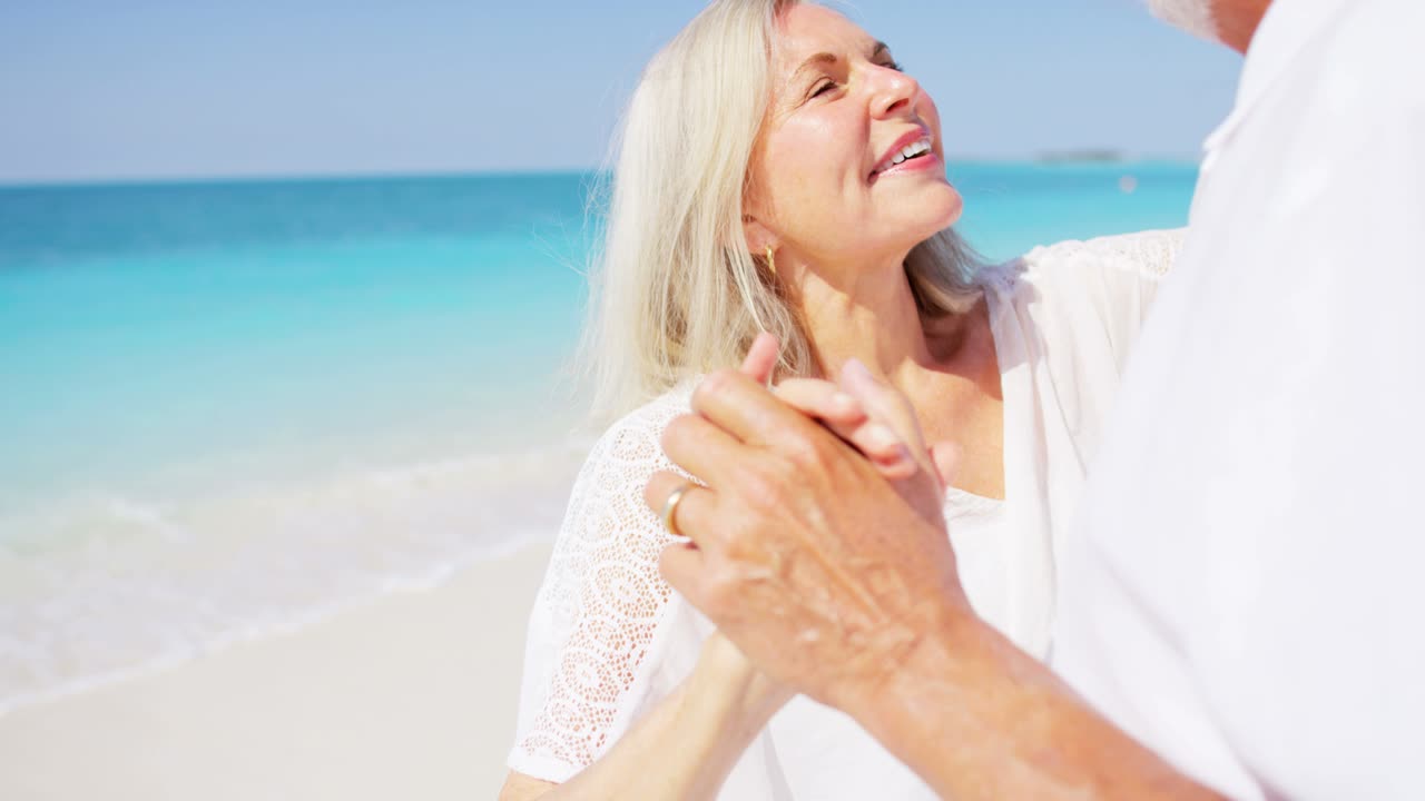 카리브 해변에서 함께 춤을 추는 고위 백인 커플