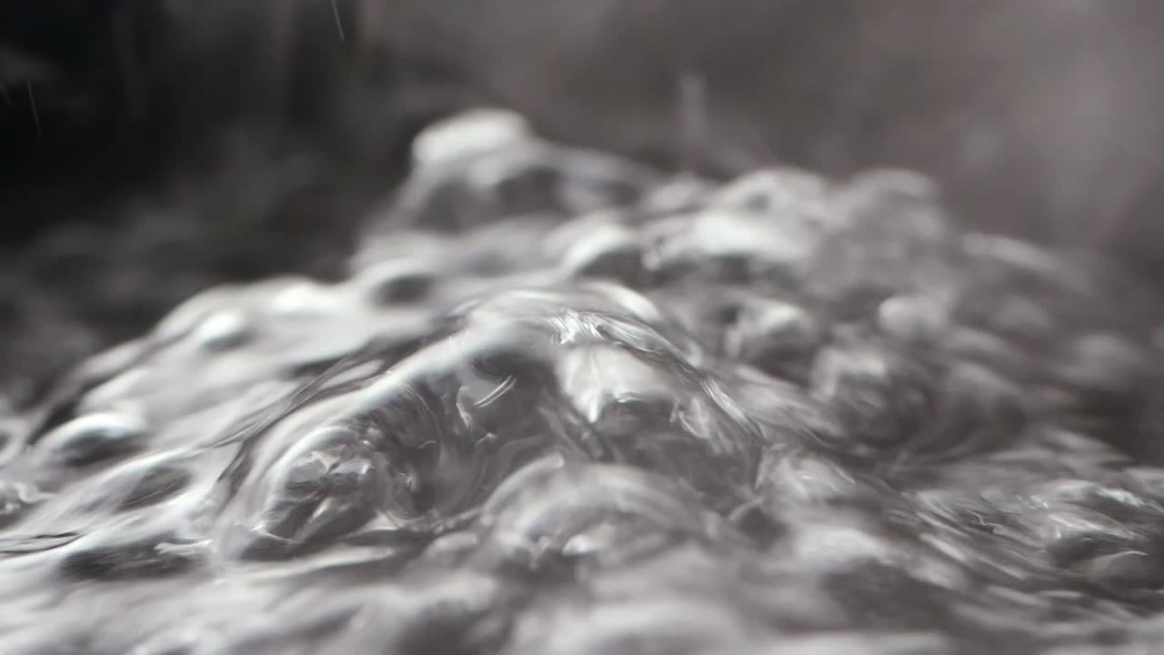 Gros plan sur de l’eau bouillante avec des bulles et de la vapeur qui s’élève