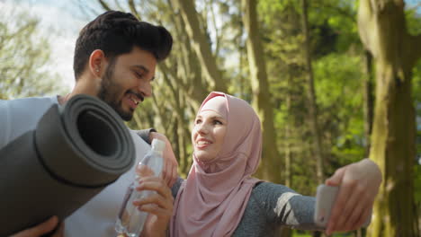 couple taking a selfie in a park after exercising