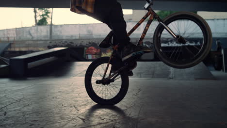 active bmx biker jumping on bicycle oundoors. guy performing jump stunt.