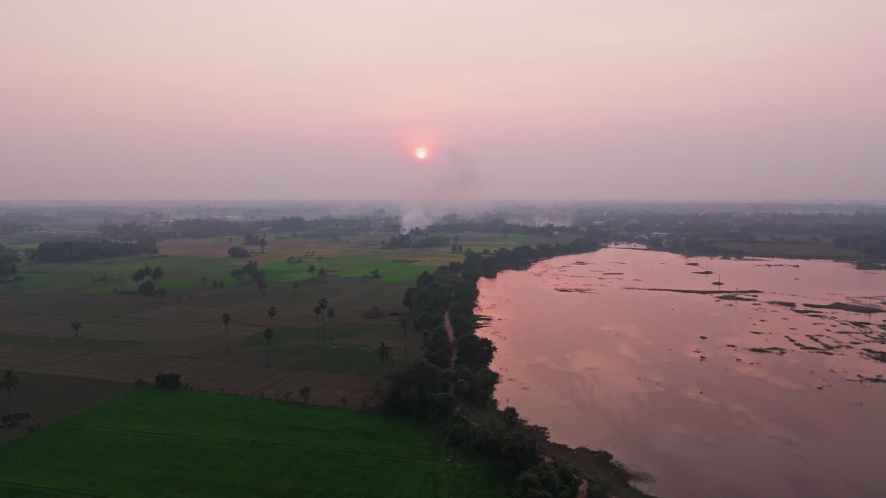 Drone view of a lake and a green field during sunset. Indian atmosphere.