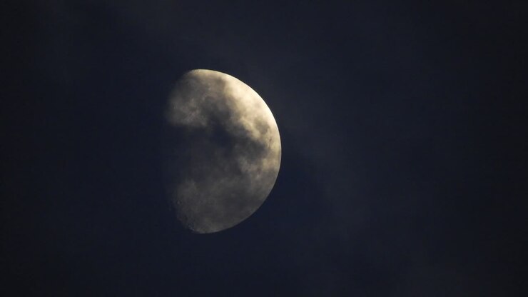 Moon at night with cloud real time. 4k video moon in the black sky. Clouds passing by moon at night. night sky with cloudy weather