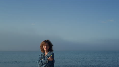 Fashionable-girl-looking-at-camera-on-seaside.-Upset-woman-posing-on-beach