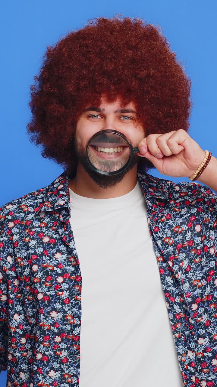 Happy smiling caucasian man holding magnifier glass on teeth health care hygiene stomatology concept