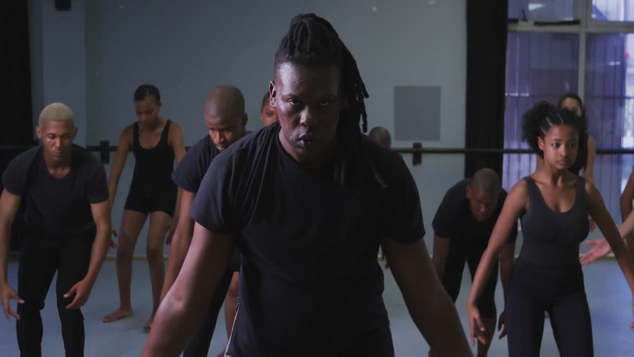Multi-ethnic group of fit male and female modern dancers practicing a dance routine