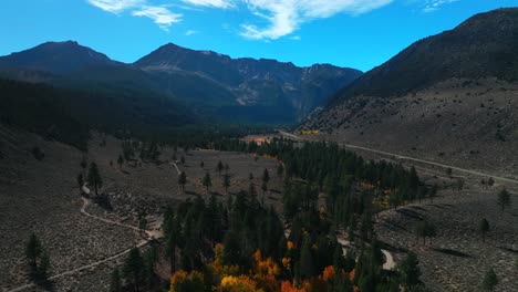 west portal entrance lee vining tioga pass road yosemite national park california aerial drone ansel adams wilderness big oak flat fall autumn yellow orange aspen trees blue skies forward motion