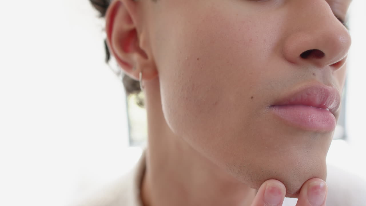 Examining smooth skin, person touching face with fingers in close-up view