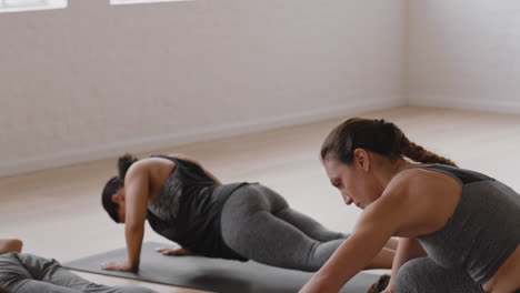 instructora de clase de yoga mujer enseñando pose de cobra a un grupo de mujeres practicando disfrutando de un estilo de vida saludable haciendo ejercicio en el gimnasio