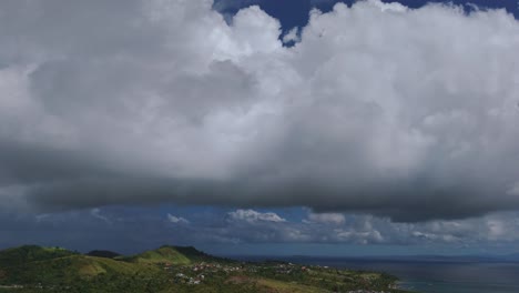 antenas de una montaña y región con densas nubes de colón flotando sobre una ciudad