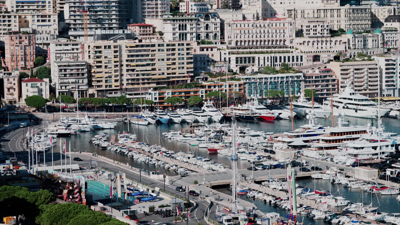 Aerial view of boats docked in the Monaco Marina with the skyline of the city on the background